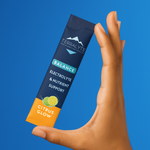 Hand holding a Terralyte supplement packet against a blue background